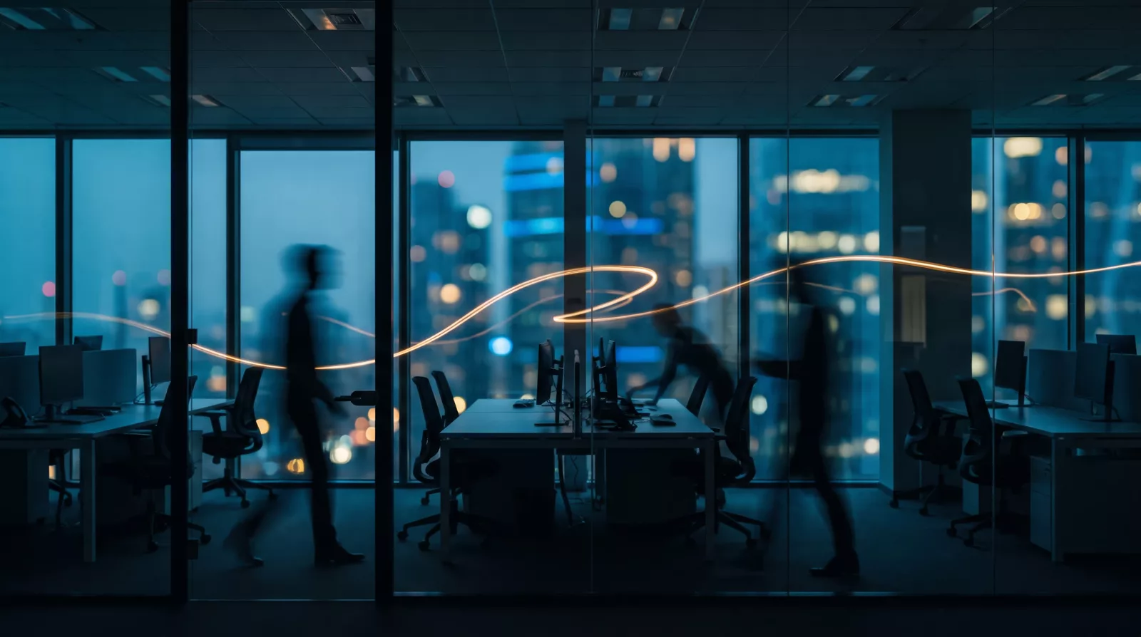 People moving through a glass-walled office at dusk